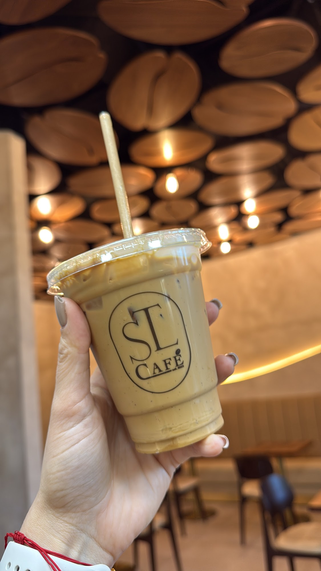 STL Café branded drink held inside the café